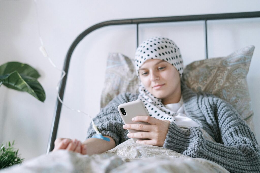 A woman undergoing cancer treatment relaxing in bed, capturing hope and resilience.